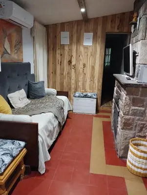 a bedroom with two beds and a stone fireplace at Abuelito dime tu in Mina Clavero