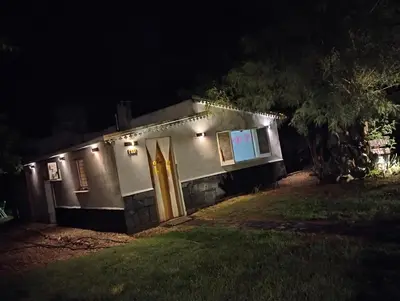 a small house with a yellow door at night at Abuelito dime tu in Mina Clavero