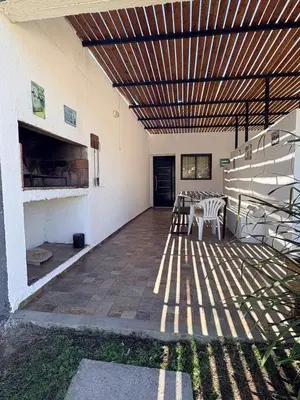 a patio with a table and chairs under a wooden ceiling at SIMION in Villa Carlos Paz