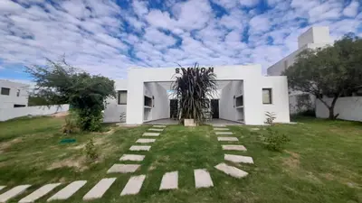 a white house with a grass yard at SIMION in Villa Carlos Paz