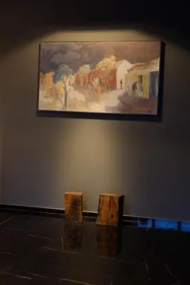 a painting hanging on a wall next to two chairs at MAE Singular Hotel in Cordoba