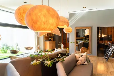 a living room with a couch and some large lights at MAE Singular Hotel in Cordoba