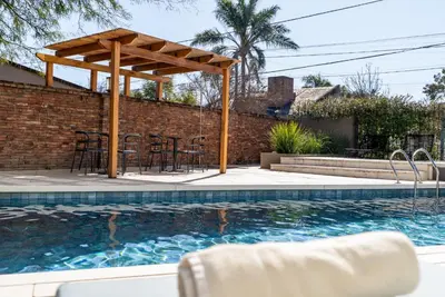 a patio with a table and chairs next to a swimming pool at MAE Singular Hotel in Cordoba
