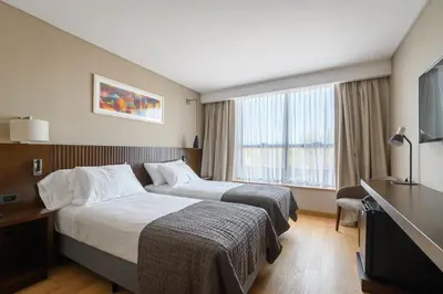 a hotel room with two beds and a television at MAE Singular Hotel in Cordoba