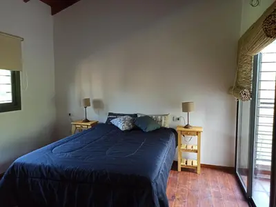 a bedroom with a blue bed and two night stands at Papa Ruku in Villa Ciudad Parque