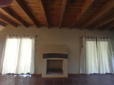 a living room with two windows and a fireplace at Papa Ruku in Villa Ciudad Parque