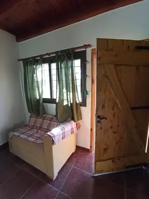 a bedroom with a bed and a wooden door at Papa Ruku in Villa Ciudad Parque