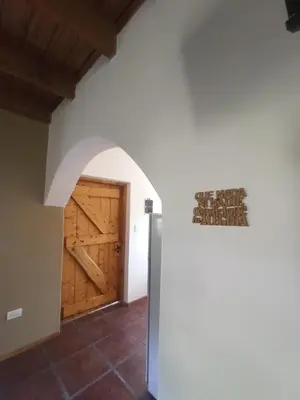 a hallway with a wooden door and a wall at Papa Ruku in Villa Ciudad Parque