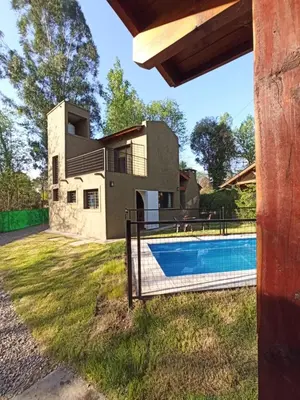 a house with a swimming pool in front of it at Papa Ruku in Villa Ciudad Parque