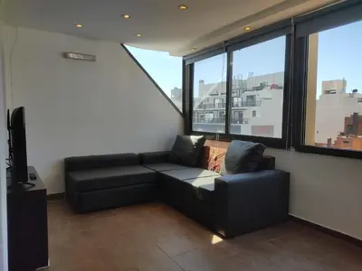 a living room with a couch and some windows at Piso Completo en Nueva Córdoba in Cordoba