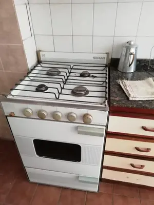 a white stove top oven sitting in a kitchen at Illía Residential Apartament in Cordoba