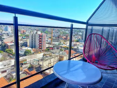 a table and a red fan on a balcony at Miralejos 7 - 100 mtrs peatonal in Villa Carlos Paz