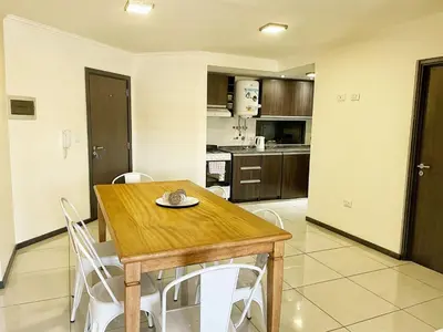 a kitchen and dining room with a wooden table and chairs at Miralejos 7 - 100 mtrs peatonal in Villa Carlos Paz