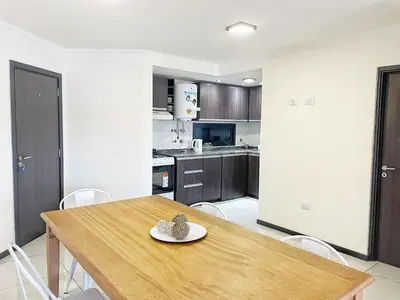 a kitchen with a wooden table and chairs at Miralejos 7 - 100 mtrs peatonal in Villa Carlos Paz