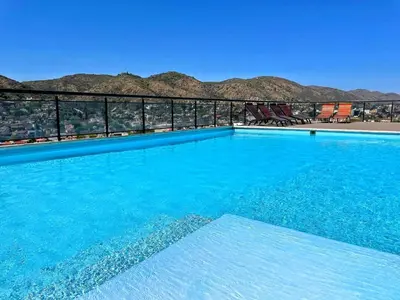 a large blue swimming pool with mountains in the background at Miralejos 7 - 100 mtrs peatonal in Villa Carlos Paz