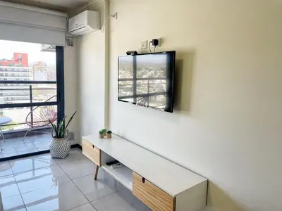 a living room with a table and a tv on a wall at Miralejos 7 - 100 mtrs peatonal in Villa Carlos Paz