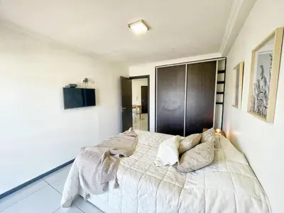 a bedroom with a bed with white sheets and pillows at Miralejos 7 - 100 mtrs peatonal in Villa Carlos Paz