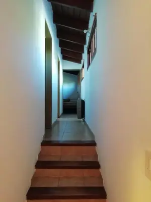 a hallway leading up to a room with white walls and stairs at Carlos Paz Colinas House in Villa Carlos Paz
