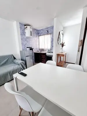 a kitchen and living room with a white table and chairs at DPTO 1 CUADRA SANATORIO ALLENDE in Cordoba
