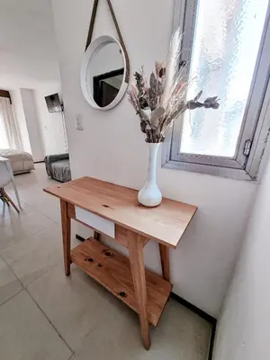 a vase of flowers on a table with a mirror at DPTO 1 CUADRA SANATORIO ALLENDE in Cordoba