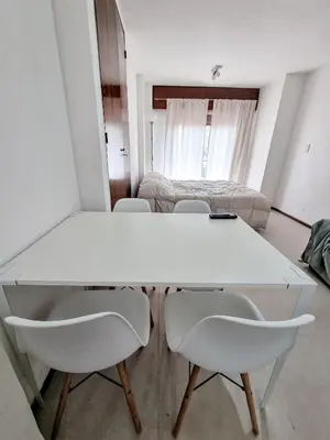 a white table and chairs in a room with a bed at DPTO 1 CUADRA SANATORIO ALLENDE in Cordoba