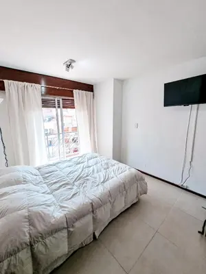 a bedroom with a bed and a large window at DPTO 1 CUADRA SANATORIO ALLENDE in Cordoba