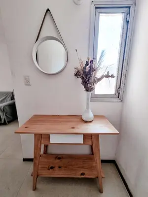 a table with a vase of flowers and a mirror at DPTO 1 CUADRA SANATORIO ALLENDE in Cordoba