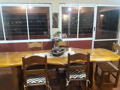 a wooden dining room table with chairs and windows at MIRADOR DEL LAGO - La Vista in Villa Parque Siquiman