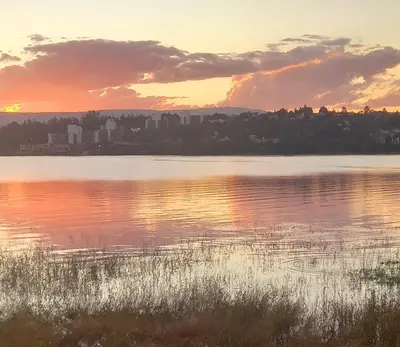 a sunset over a lake with a city in the background at MIRADOR DEL LAGO - La Vista in Villa Parque Siquiman