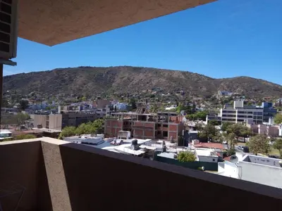 a view of a city with a mountain in the background at Torre del Lago V in Villa Carlos Paz