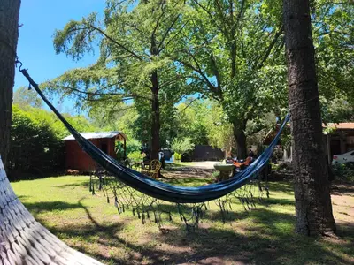 a hammock hanging between two trees in a park at Casa del arroyo in Villa General Belgrano