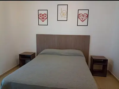 a bedroom with a bed with four pictures on the wall at Apartamentos Santa Rosa 1B in Cordoba