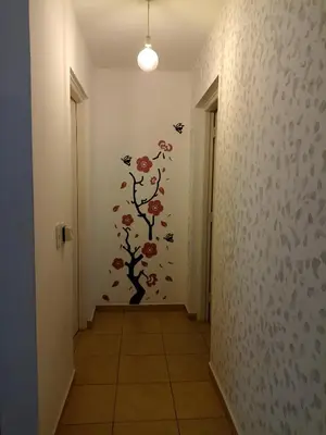 a hallway with a wall with a tree and butterflies at Apartamentos Santa Rosa 1B in Cordoba