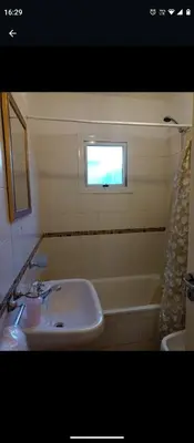 a bathroom with a sink and a tub and a window at Apartamentos Santa Rosa 1B in Cordoba