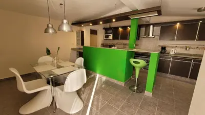 a kitchen with a glass table and white chairs at Victorino House en el Cerro de las Rosas con cochera in Cordoba