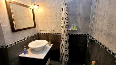 a bathroom with a toilet and a sink and a mirror at Victorino House en el Cerro de las Rosas con cochera in Cordoba