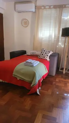 a bedroom with a large bed with a red blanket at cañada in Cordoba
