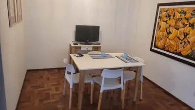 a room with a table with chairs and a television at cañada in Cordoba