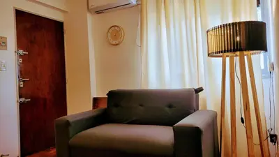 a living room with a chair and a lamp at cañada in Cordoba