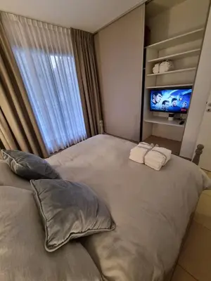 a large bed with two pillows and a television in a bedroom at Nueva Córdoba - Premium in Cordoba