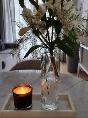 a candle and a vase with flowers on a table at Nueva Córdoba - Premium in Cordoba