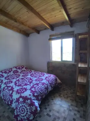 a bedroom with a bed and a window at Cabañas La Rustica 6p in Bialet Massé