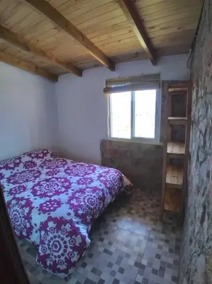 a bedroom with a bed in a room with a window at Cabañas La Rustica 6p in Bialet Massé