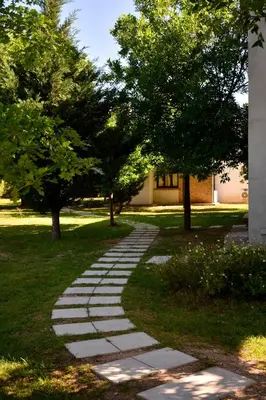 a stepping stone path in a park with trees at La Rosa Apart Hotel - Solo Parejas in Mina Clavero