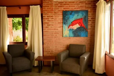 a room with two chairs and a painting on the wall at La Rosa Apart Hotel - Solo Parejas in Mina Clavero