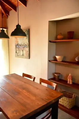 a dining room with a wooden table and chairs at La Rosa Apart Hotel - Solo Parejas in Mina Clavero