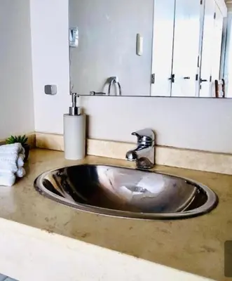 a sink in a bathroom with a large mirror at DEPARTAMENTO VIP PREMIUM EN EL CENTRO - Arte y Vistas panorámicas a toda la ciudad y el río in Cordoba