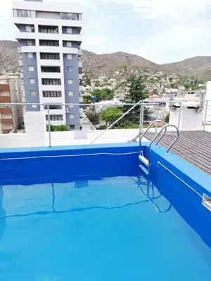 a large swimming pool with a view of a building at Departamento Sorrentos in Villa Carlos Paz