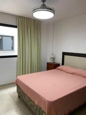 a bedroom with a pink bed and a window at Departamento Sorrentos in Villa Carlos Paz