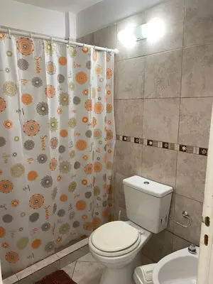 a bathroom with a toilet and a shower curtain at Departamento Sorrentos in Villa Carlos Paz